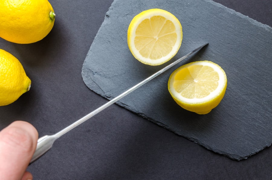 Slice lemon cut with a knife on a board