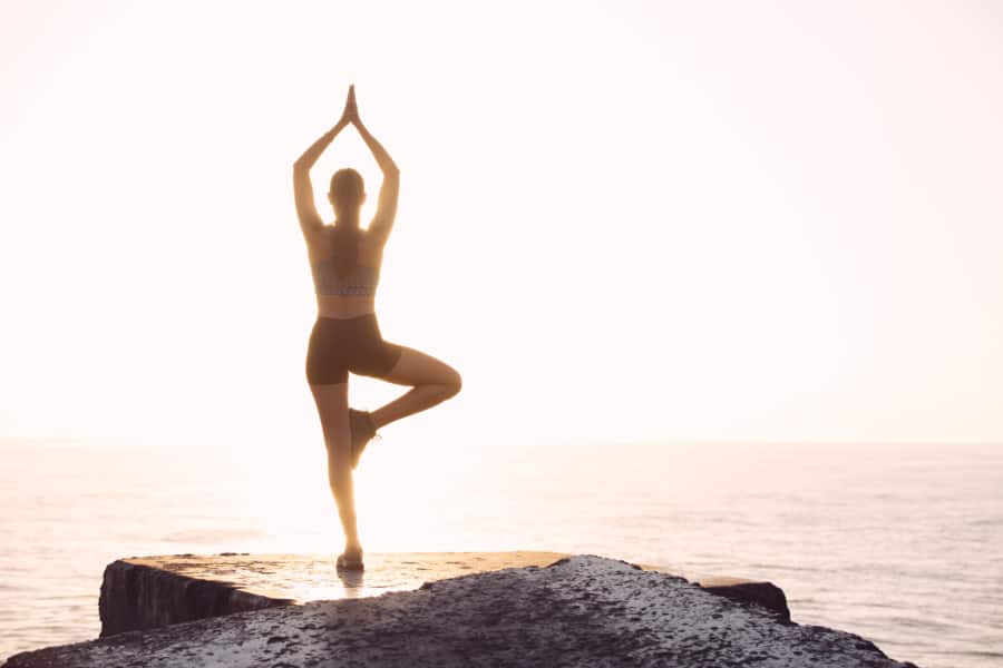 Woman Doing Yoga Pose Facing Sea