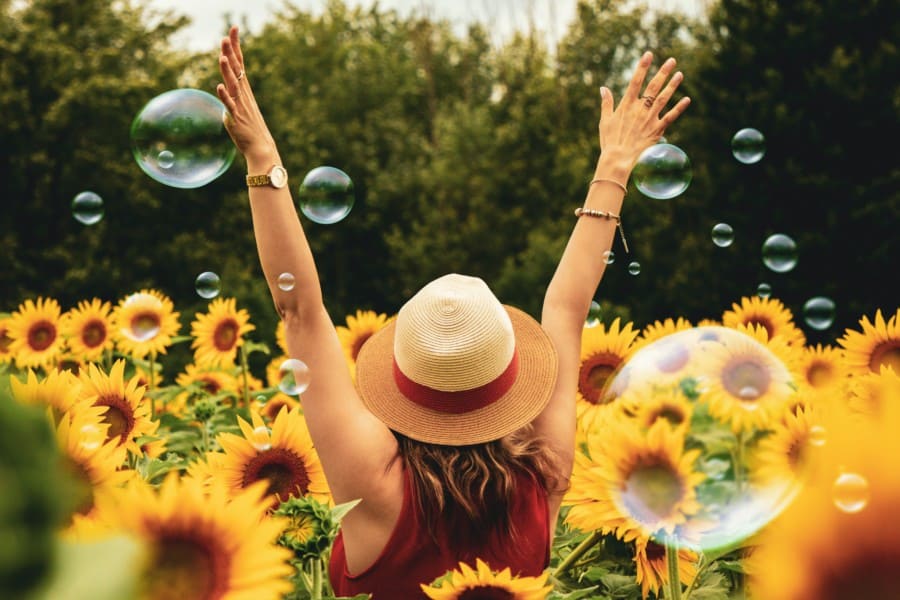 Happy woman surrounded by sunflowers