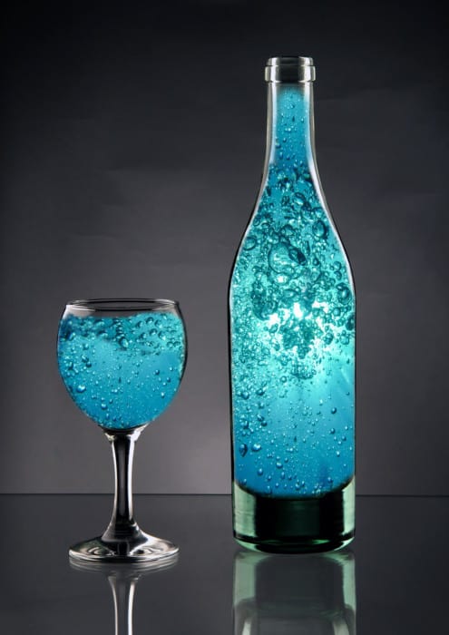 Bottle With Blue Liquid On gray Background